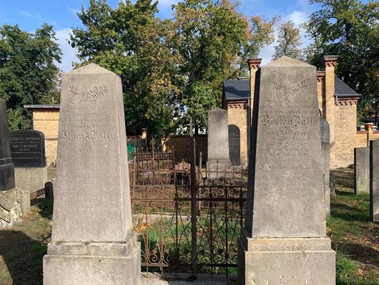 Gravestones made of stone. Surrounded by a lawn