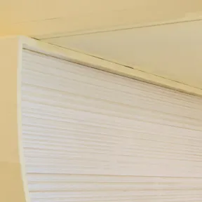 Detailaufnahme der Installation mit hölzernen Buchskulpturen in Gelb.