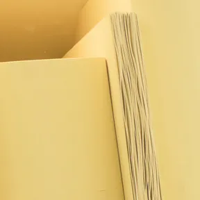 Detailaufnahme der Installation mit hölzernen Buchskulpturen in Gelb.