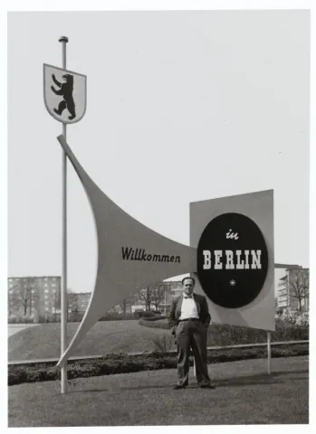 Fred Stein, behind him a sign reading &ldquo;Welcome to Berlin.&rdquo;