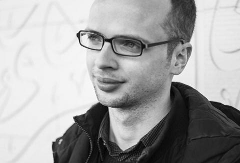 Schwarz-Weiß-Porträt eines jungen Mannes mit Brille im Halbprofil