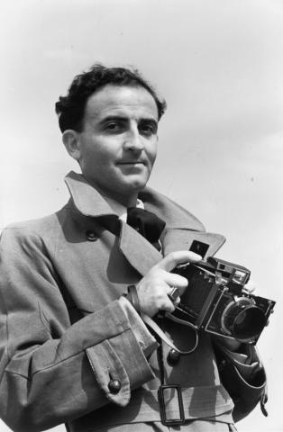 Schwarz-Weiß-Fotografie eines Mannes, der eine Kamera hält