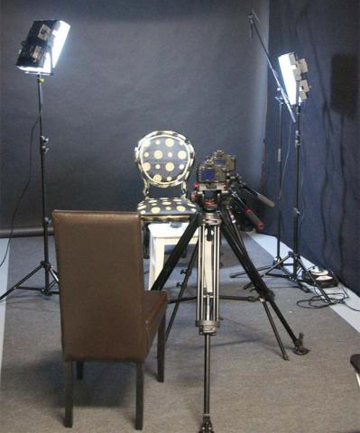 Der leere Stuhl bei den Dreharbeiten zwischen zwei Scheinwerfern und hinter einer Kamera