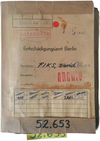 Color photo: File case with name, record number, various stamped markings
