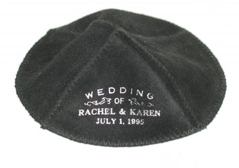 Schwarze Kippa mit der weißen Aufschrift „Wedding of Rachel & Karen Juli 1, 1995“