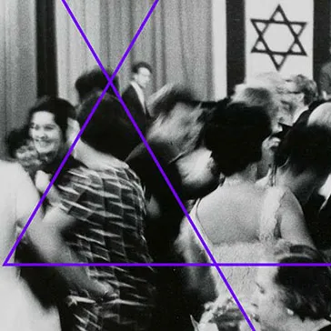 Schwarzweiß-Fotografie: Festlich gekleidete Menschen beim Tanzen, im Hintergrund ist eine mit zwei israelischen Fahnen geschmückte Bühne zu sehen, auf der eine Musikkapelle spielt.