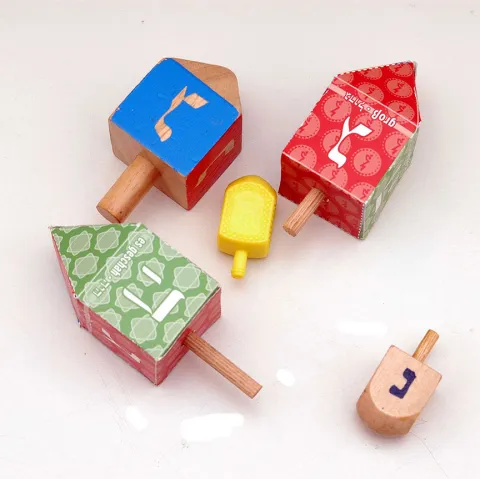 Fünf bunte Kreisel mit hebräischen Buchstaben