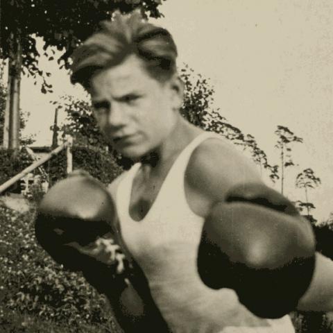 Schwarz-weiß-Foto: ein Mann mit Boxhandschuhen.