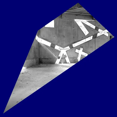 Blaues Passpartout um ein schwarz-wei&szlig;-Foto eines noch im Bau befindlichen, leeren Raums, in dessen Betonw&auml;nden sehr schr&auml;ge Fenster sind, durch die Licht einf&auml;llt.