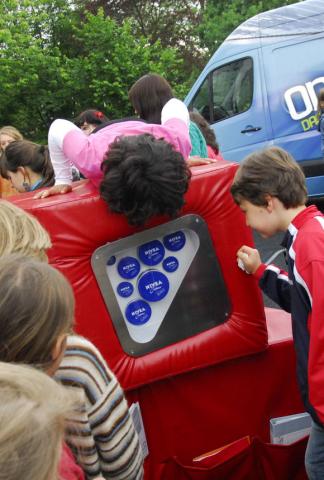 Kinder sind um und auf den mobilen Ausstellungswürfeln versammelt. Darin entdecken sie unterschiedlich große Nivea-Dosen.