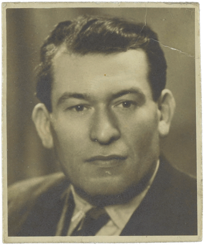 Black and white portrait of a white man with combed back hair.