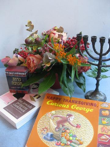 Eine Menora, ein Blumenstrauß und das Buch „Curious George“