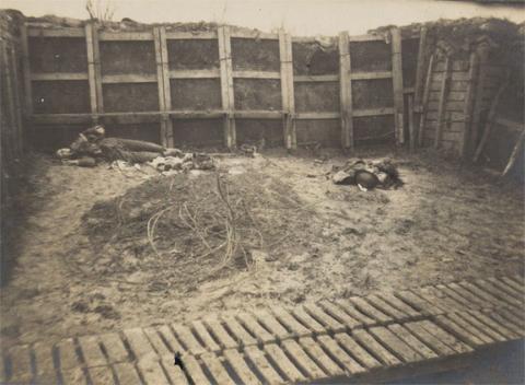 Schwarz-weiß Fotografie von einem Schützengraben mit einem totem Soldaten.