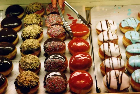 Viele bunte Krapfen in einer Verkaufsauslage