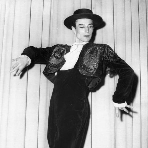 Black and white photo: a man with hat and bolero dancing.