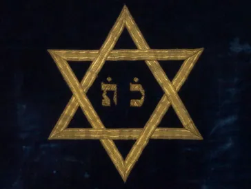 Golden Magen David on dark background, detail from a Torah curtain.