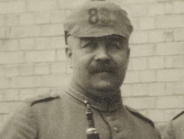 Black and white portrait of a man with a spiked helmet.