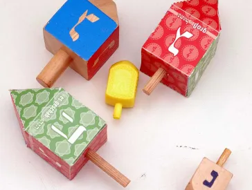 5 Dreidel aus unterschiedlichen Materialien.