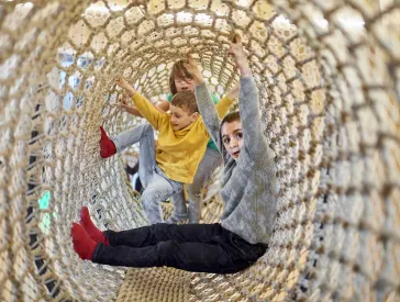 Drei Kinder turnen im ANOHA in der Kletterschlange.