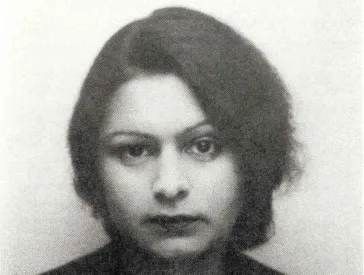A woman with dark hair looks into the camera. It is a black-and-white photograph.