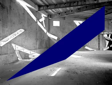 Schwarz-wei&szlig;-Foto eines noch im Bau befindlichen, leeren Raums, in dessen Betonw&auml;nden sehr schr&auml;ge Fenster sind, durch die Licht einf&auml;llt.