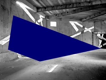 Schwarz-wei&szlig;-Foto eines noch im Bau befindlichen, leeren Raums, in dessen Betonw&auml;nden sehr schr&auml;ge Fenster sind, durch die Licht einf&auml;llt.