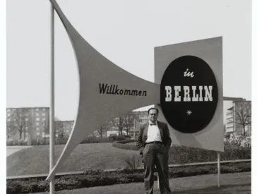 Fred Stein, hinter ihm Schilder mit der Aufschrift &raquo;Willkommen in Berlin&laquo;.