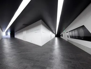 Fotografie: Blick in zwei Achsen, in den Wänden eingelassene Vitrinen und Städtenamen 