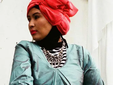 A woman in dress and hijab.