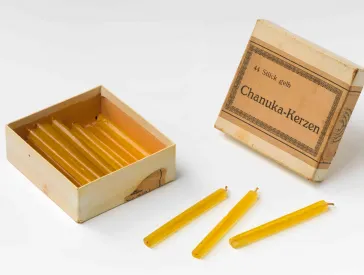 Ein alter geöffneter Karton mit gelben Kerzen.