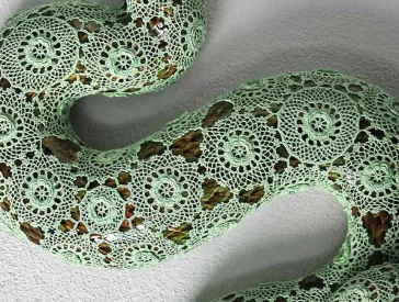 Eine Schlange auf gehäkelten Stoff.