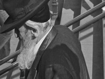 Schwarz-weiß Fotografie eines Mannes mit Anzug und Hut.