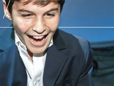 A boy laughs into the camera.