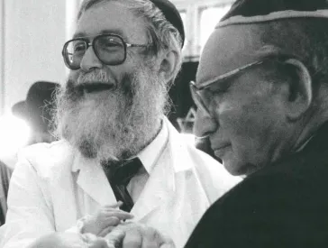 Zwei ältere Männer und ein Baby in deren Mitte.