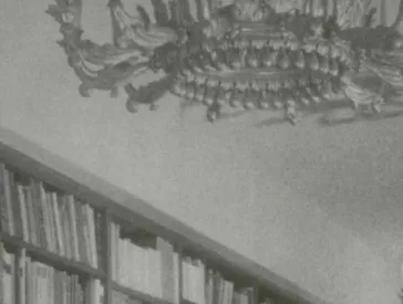 Black and white photograph of a library with large chandeliers (detail).