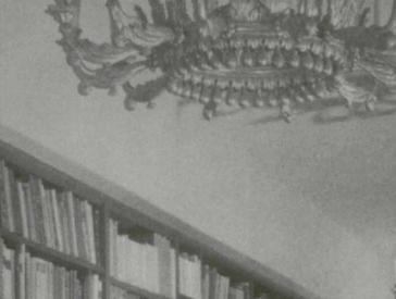 Black and white photograph of a library with large chandeliers (detail).