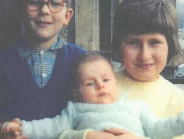 Zwei Kinder halten ein Baby.