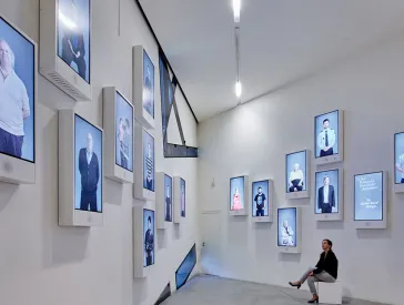 Room view with monitors on the wall showing many different people