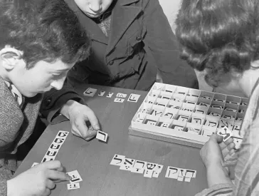 Kinder legen Plättchen mit hebräischen Schriftzeichen zu Wörtern zusammen