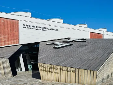 Vorderfront der W. Michael Blumenthal Akademie mit dem Schriftzug: Höre die Wahrheit, wer sie auch spricht.