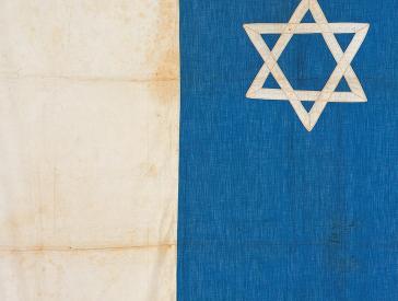 Blue and white flag with Star of David on the blue background.