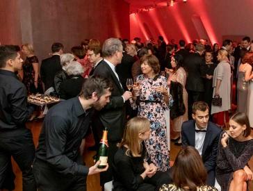 People in evening dress, champagne and appetizers are distributed.