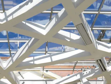 Deckenkonstruktion des Glashofs vor blauem Himmel.