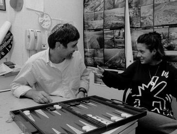 Schwarz-weiß-Foto: zwei Personen sitzen an einem Backgammon Spiel.