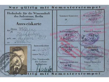 Blue paper ID card with portrait photo, filled in by hand and stamped