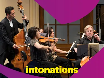 Fünf Musikerinnen und Musiker beim Musizieren auf der Bühne