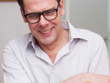 A man laughs into the camera.