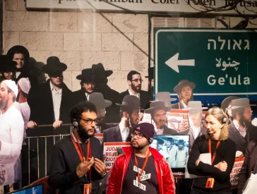 Gruppenführung in einem unübersichtlichen, mit Pappfiguren vollgestellten Ausstellungsraum