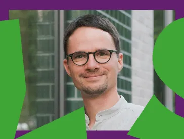 Man with glasses looks friendly into the camera.