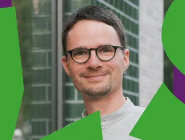 Man with glasses looks friendly into the camera.